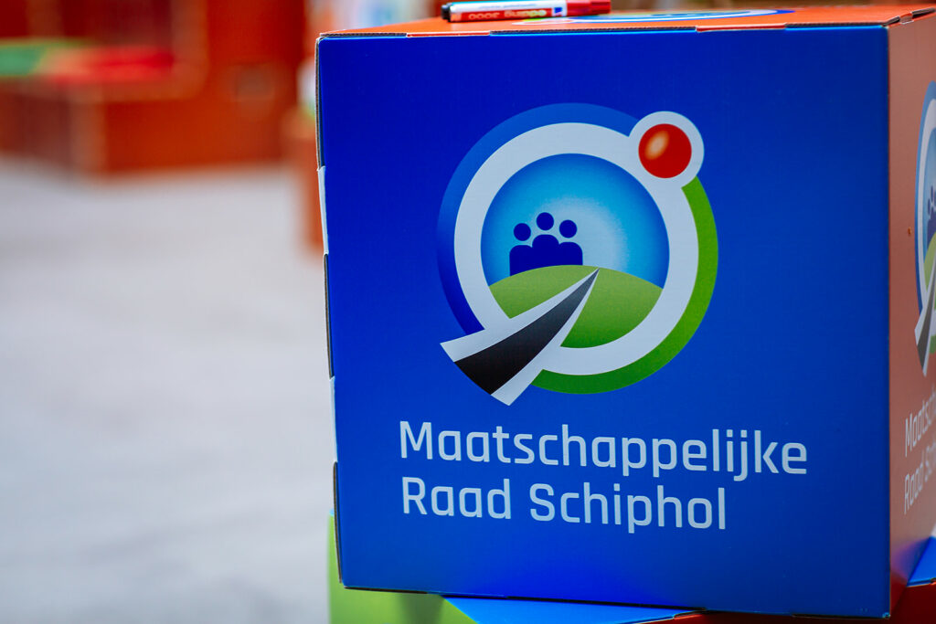 Kartonnen kubus met het logo van de Maatschappelijke Raad Schiphol