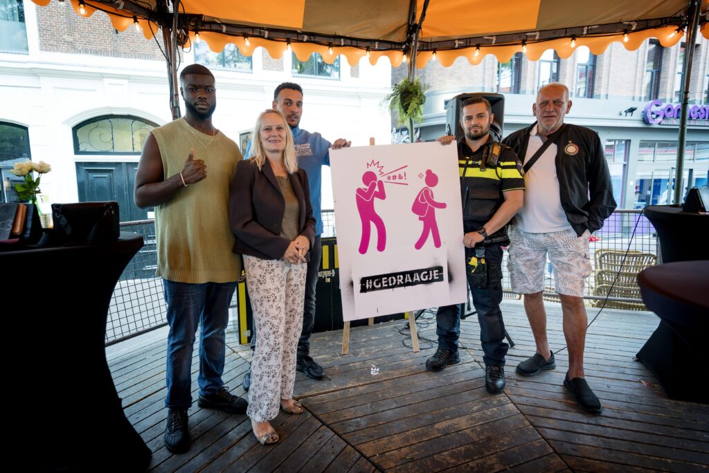 Mannen uit de campagne op de foto met Korrie Louwes en een bord met de campagne-uitingen